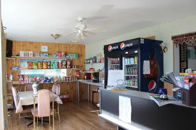 a coffee shop with a counter and a table with chairs at Raval Paradise Motel and RV Park in Youngstown