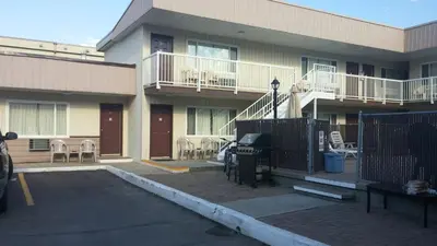 a parking lot in front of a building with chairs at Shoreline Resort Condominiums in Penticton