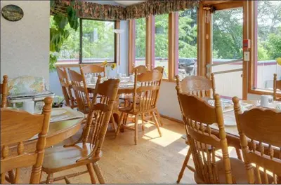 a dining room with a table and chairs and windows at Marketa's Bed and Breakfast in Victoria