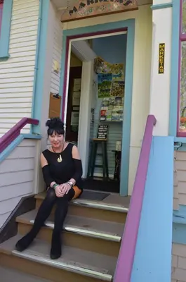 a woman sitting on the steps of a house at Marketa's Bed and Breakfast in Victoria
