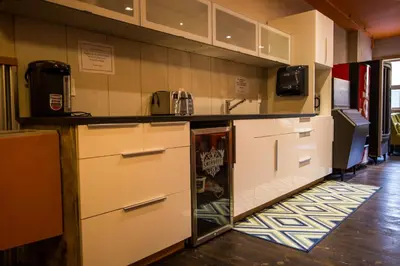 a kitchen with white cabinets and a counter top at Adventure Hotel in Nelson