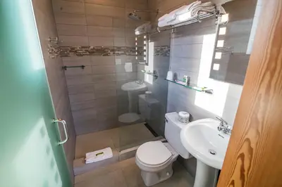 a small bathroom with a toilet and a sink at Adventure Hotel in Nelson