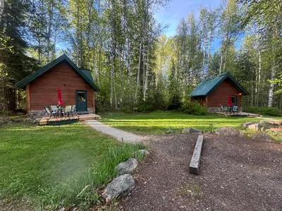 a log cabin in the woods with a porch at Across the Creek Cabins in Clearwater