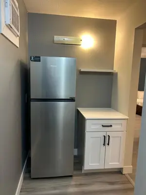 a kitchen with a stainless steel refrigerator and a counter at Rimbey Motor Inn in Rimbey