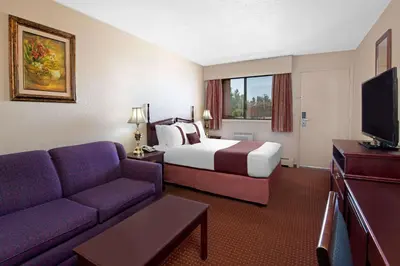 a hotel room with a bed and a couch at Deer Park Inn in Red Deer