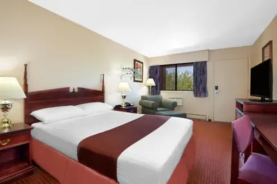 a hotel room with a large bed and a television at Deer Park Inn in Red Deer