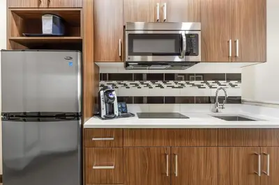 a kitchen with a stainless steel refrigerator and a microwave at Best Western Plus Hinton Inn & Suites in Hinton