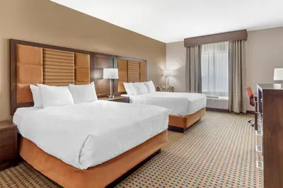 a hotel room with two beds and a television at Best Western Plus Hinton Inn & Suites in Hinton