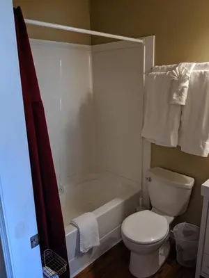 a bathroom with a toilet and a bath tub at Nimpkish Hotel in Alert Bay