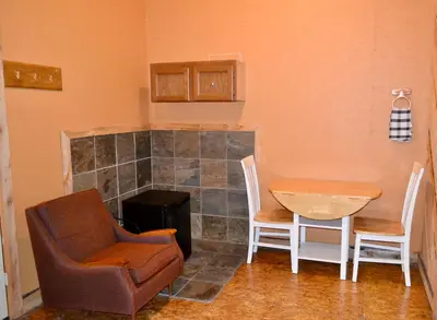 a living room with a chair and a table at Schott's Lake Conference & Resort in Sundre