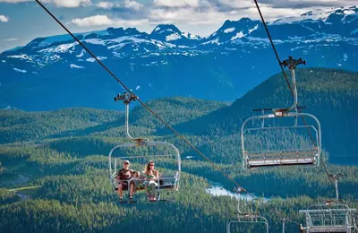 two people riding a gondola in the mountains at Old House Hotel in Courtenay