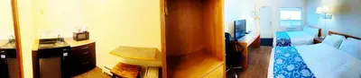 a hotel room with a bed and a television at Grande Mountain Lodge in Grande Cache