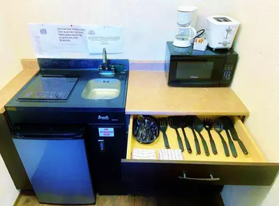 a kitchen with a counter with a sink and a mixer at Grande Mountain Lodge in Grande Cache