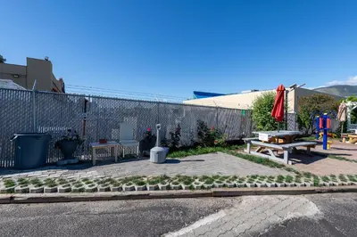a patio with a bench and a table and a fence at 5000 Motel in Penticton