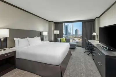 a hotel room with a large white bed and a television at Hilton Vancouver Metrotown in Burnaby
