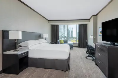 a hotel room with a bed and a flat screen tv at Hilton Vancouver Metrotown in Burnaby