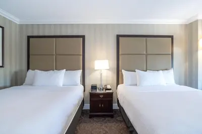a hotel room with two beds and a table with a lamp at Sandman Signature Edmonton Downtown Hotel in Edmonton