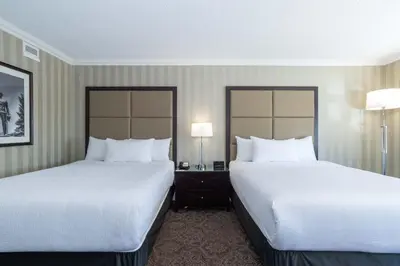 a hotel room with two beds and two lamps at Sandman Signature Edmonton Downtown Hotel in Edmonton