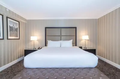 a bedroom with a large white bed and two lamps at Sandman Signature Edmonton Downtown Hotel in Edmonton