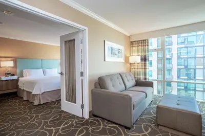 a hotel room with a bed and a couch at Hampton Inn & Suites, by Hilton - Vancouver Downtown in Vancouver