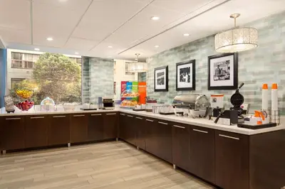 a large kitchen with brown cabinets and a large window at Hampton Inn & Suites, by Hilton - Vancouver Downtown in Vancouver