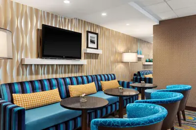 a waiting room with blue chairs and a flat screen tv at Hampton Inn & Suites, by Hilton - Vancouver Downtown in Vancouver