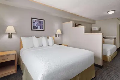 a hotel room with a large bed with white pillows at Travelodge by Wyndham Fort McMurray in Fort McMurray