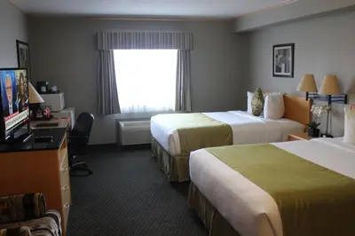 a hotel room with two beds and a television at Travelodge by Wyndham Fort McMurray in Fort McMurray