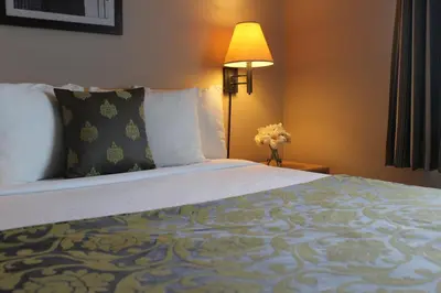 a hotel room with a large bed and a lamp at Travelodge by Wyndham Fort McMurray in Fort McMurray