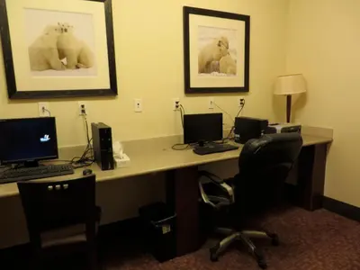 an office with a desk with two computers and chairs at Sigma Inn & Suites Hudson's Hope in Hudson Hope