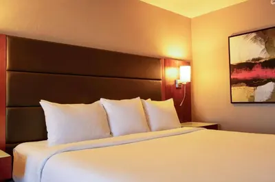 a bed with white pillows in a hotel room at Radisson Hotel & Suites Fort McMurray in Fort McMurray