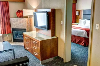 a hotel room with a television and a bed at Radisson Hotel & Suites Fort McMurray in Fort McMurray
