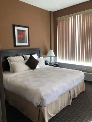 a large white bed in a hotel room at Nomad Hotel & Suites in Fort McMurray