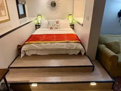 a small bed in a small room with a couch at Barclay House Bed and Breakfast in Vancouver