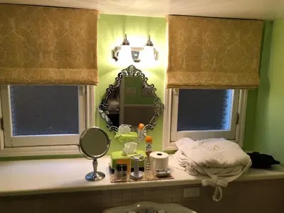 a bathroom counter with a mirror and a sink at Barclay House Bed and Breakfast in Vancouver