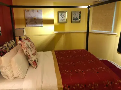 a bedroom with a bed with a red comforter at Barclay House Bed and Breakfast in Vancouver
