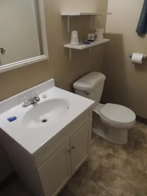 a bathroom with a white sink and a toilet at 100 Mile Motel & RV Park in One Hundred Mile House