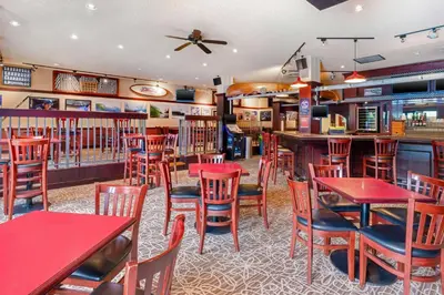 a restaurant with red tables and chairs and a bar at Best Western Plus Barclay Hotel in Port Alberni