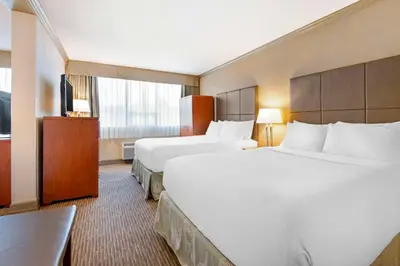 a hotel room with two beds and a television at Best Western Plus Barclay Hotel in Port Alberni