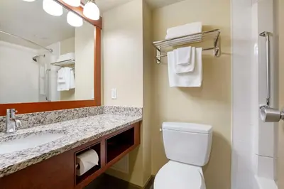 a bathroom with a toilet and a sink and a mirror at Best Western Plus Barclay Hotel in Port Alberni