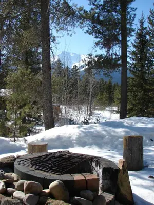 a fire pit in the snow with snow covered trees at Mica Mountain Lodge & Log Cabins in Tete Jaune Cache