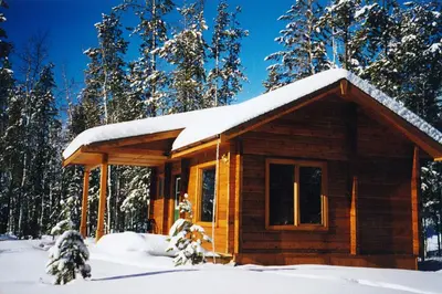 a log cabin with snow on top of it at Mica Mountain Lodge & Log Cabins in Tete Jaune Cache