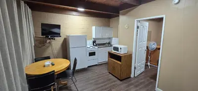 a small kitchen with a table and a kitchen with a refrigerator at Flamingo Motel in Penticton
