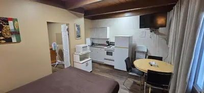a small kitchen with a table and a small kitchen with a table and chairs at Flamingo Motel in Penticton