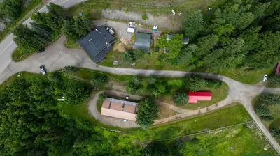an aerial view of a farm with a building and trees at Helmcken Falls Lodge Cabin Rooms and RV Park in Clearwater