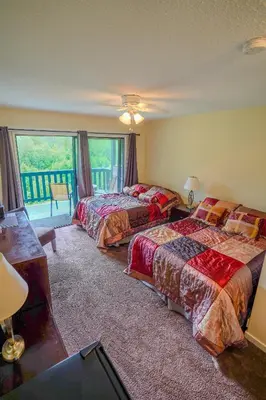 a hotel room with two beds and a balcony at Helmcken Falls Lodge Cabin Rooms and RV Park in Clearwater