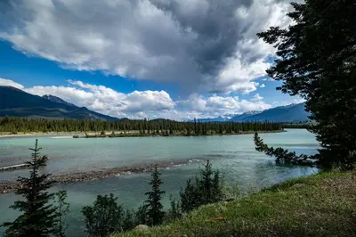 a view of a river with mountains in the background at Pine Bungalows in Jasper