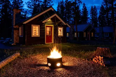 a fire pit in front of a house at night at Pine Bungalows in Jasper