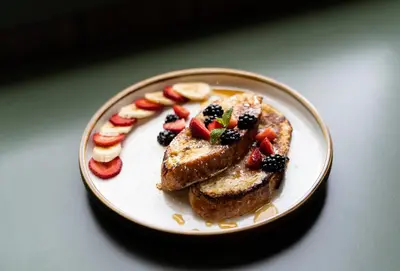 a plate of food with french toast and fruit on it at Pine Bungalows in Jasper