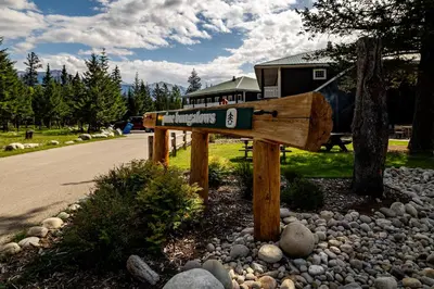 a wooden sign on the side of a road at Pine Bungalows in Jasper